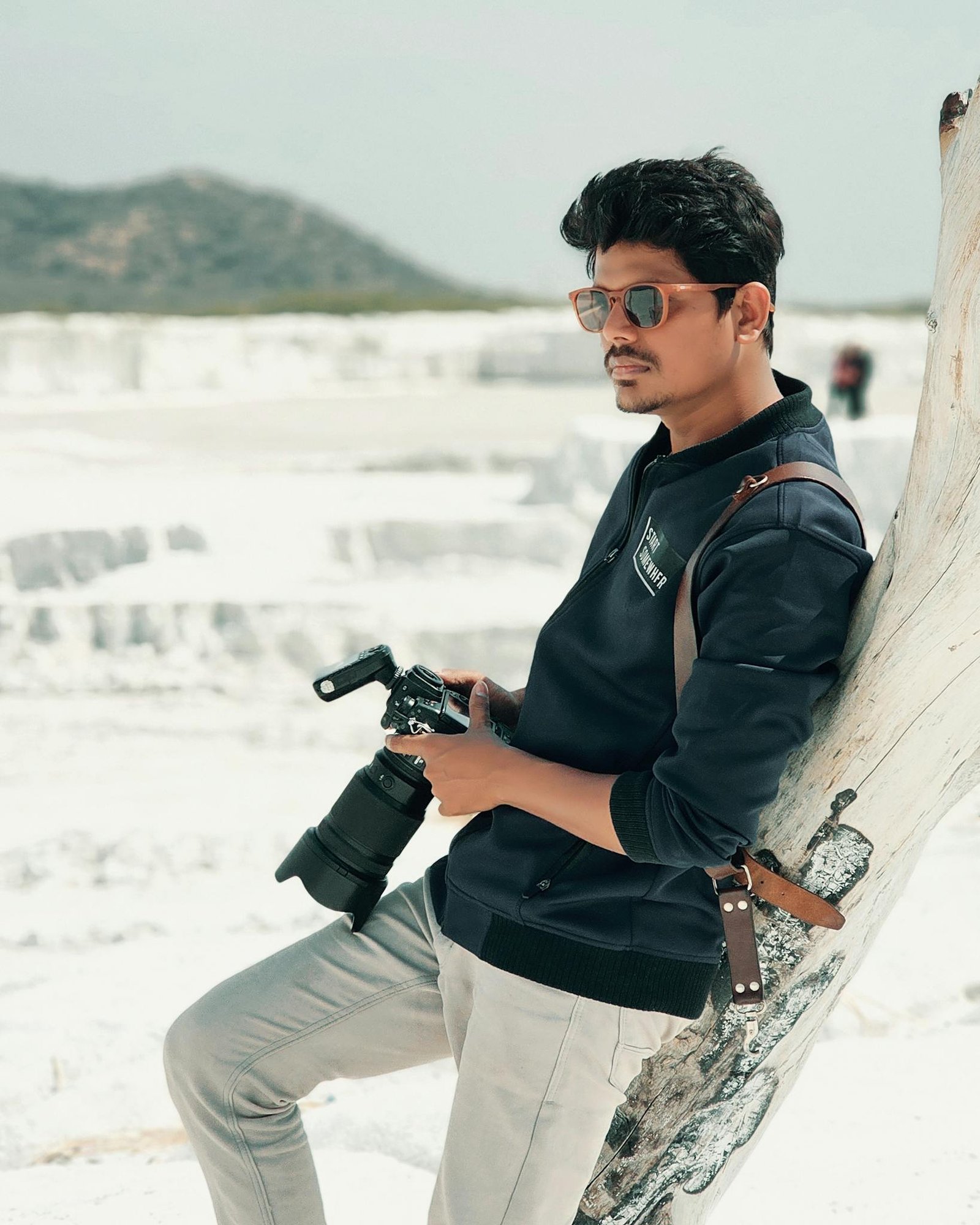 Man with camera poses in Jaipur's desert, exemplifying lifestyle photography.